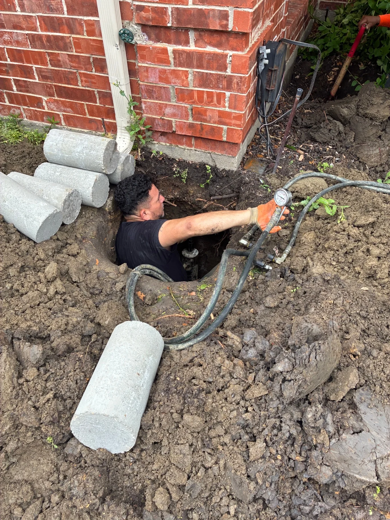 Cace technician installing a concrete pressed piling beside a brick slab foundation